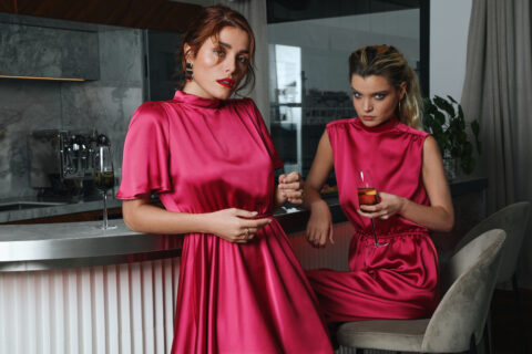 Les deux modèles portent les robes de soirée, gala ou demoiselle d'honneur conçues sur-mesure en satin rose framboise de la collection Robertha